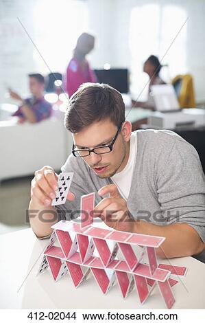Picture - Businessman making house of cards in office. Fotosearch
