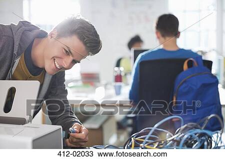 Stock Image - Businessman plugging in printer in office. Fotosearch