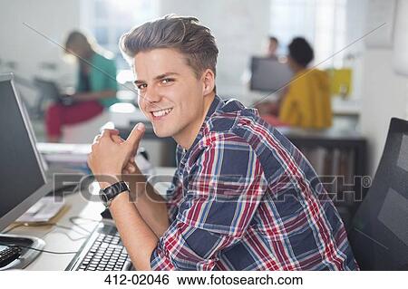 Stock Photograph - Businessman smiling at desk. Fotosearch