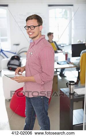 Stock Photograph - Businessman using digital tablet in office. Fotosearch