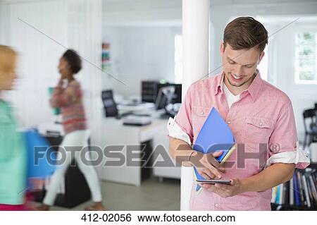 Businessman using digital tablet in office View Large Photo Image Stock Photograph - Businessman using digital tablet in office. Fotosearch