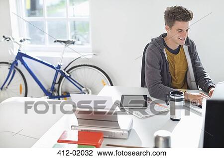 Businessman working at desk in office View Large Photo Image Stock Image - Businessman working at desk in office. Fotosearch