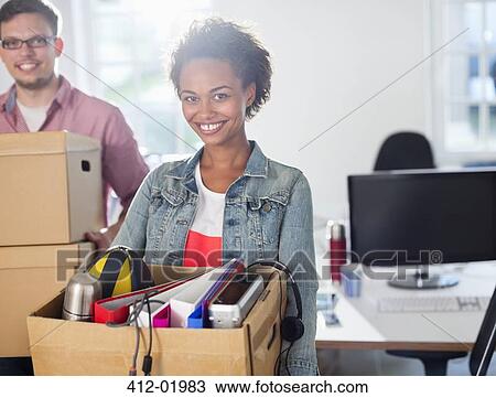 Stock Image - Businesswoman carrying box of belongings. Fotosearch