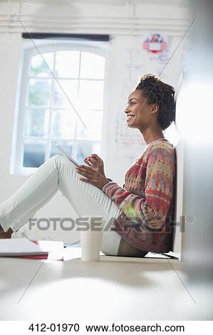 Stock Image - Businesswoman making notes in office. Fotosearch