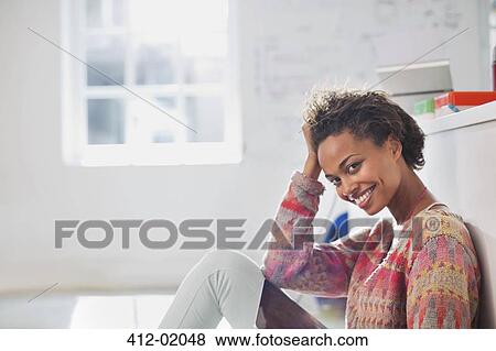 Stock Photo - Businesswoman sitting on floor in office. Fotosearch