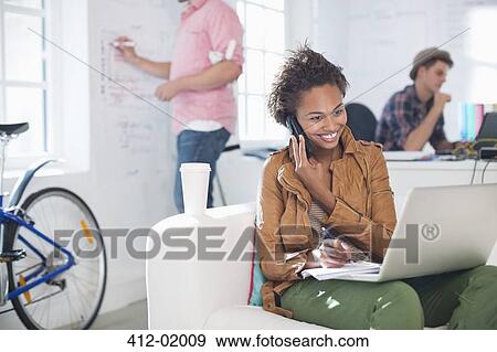 Stock Photo - Businesswoman taking notes on phone in office. Fotosearch