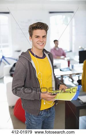 Stock Photo - Man wearing headphones in office. Fotosearch