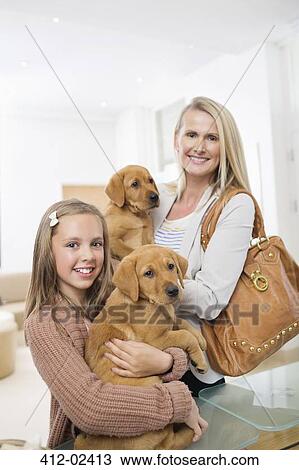 Mother and daughter holding dogs in vet's surgery View Large Photo Image Stock Image - Mother and daughter holding dogs in vet's surgery. Fotosearch