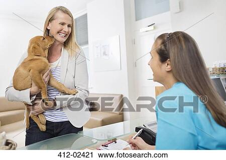 Owner bringing dog to vet's surgery View Large Photo Image Stock Image - Owner bringing dog to vet's surgery. Fotosearch