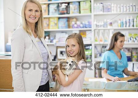 Picture - Owners bringing dog to vet's surgery. Fotosearch