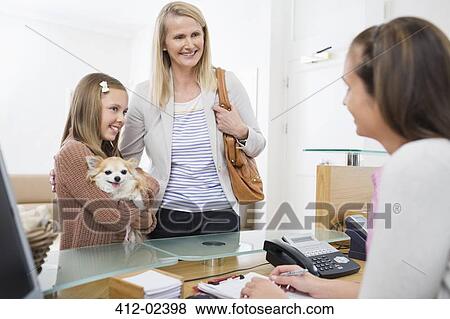 Stock Photo - Owners bringing dog to vet's surgery. Fotosearch