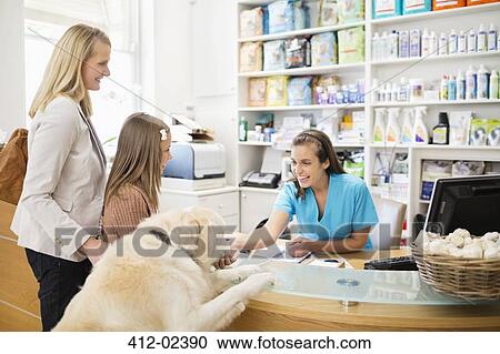 Receptionist greeting dog in vet's surgery View Large Photo Image Stock Image - Receptionist greeting dog in vet's surgery. Fotosearch