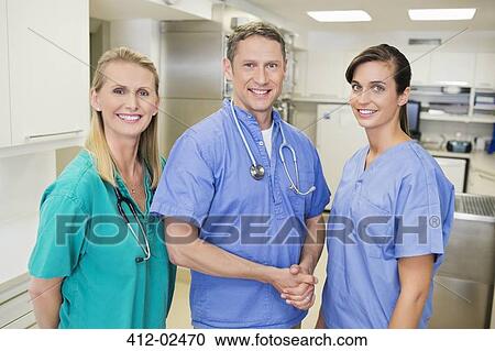 Smiling veterinarians standing together in vet's surgery View Large Photo Image Stock Image - Smiling veterinarians standing together in vet's surgery. Fotosearch