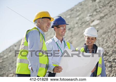 Business people reading blueprints in quarry View Large Photo Image Stock Photo - Business people reading blueprints in quarry. Fotosearch