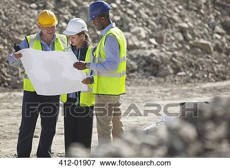 Business people reading blueprints in quarry View Large Photo Image Stock Photo - Business people reading blueprints in quarry. Fotosearch