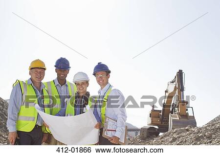 Stock Photograph - Business people reading blueprints in quarry. Fotosearch