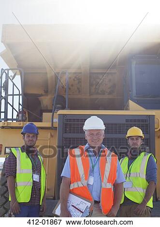 Businessman and workers by machinery on site View Large Photo Image Stock Photo - Businessman and workers by machinery on site. Fotosearch