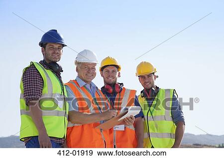 Stock Photo - Businessman and workers smiling on site. Fotosearch