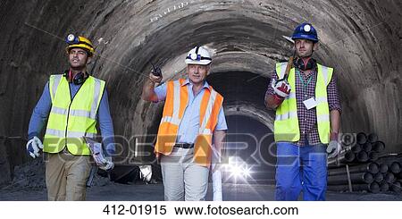 Businessman and workers walking in tunnel View Large Photo Image Stock Photography - Businessman and workers walking in tunnel. Fotosearch
