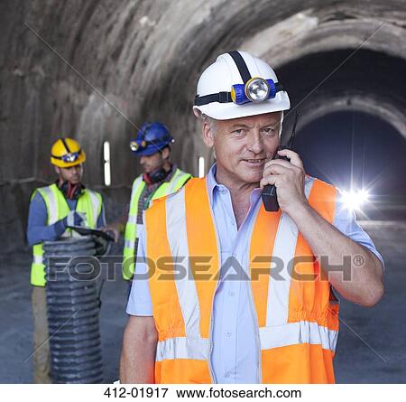 Businessman using walkie-talkie in tunnel View Large Photo Image Stock Photo - Businessman using walkie-talkie in tunnel. Fotosearch