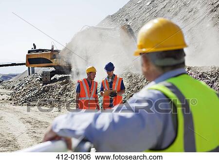 Businessman watching workers in quarry View Large Photo Image Stock Photograph - Businessman watching workers in quarry. Fotosearch