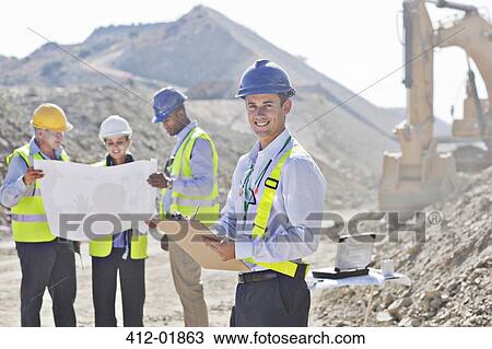 Businessmen reading blueprints in quarry View Large Photo Image Stock Image - Businessmen reading blueprints in quarry. Fotosearch