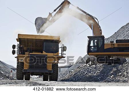 Digger and truck working in quarry View Large Photo Image Stock Image - Digger and truck working in quarry. Fotosearch