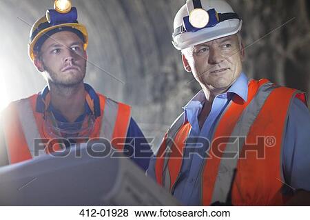Worker and businessman with blueprints in tunnel View Large Photo Image Stock Photo - Worker and businessman with blueprints in tunnel. Fotosearch