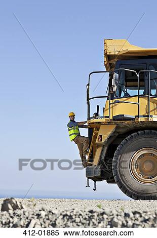 Worker climbing machinery in quarry View Large Photo Image Stock Photography - Worker climbing machinery in quarry. Fotosearch