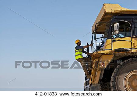 Worker climbing machinery on site View Large Photo Image Stock Image - Worker climbing machinery on site. Fotosearch