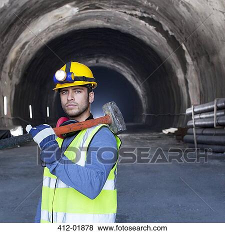 Worker holding sledgehammer in tunnel View Large Photo Image Stock Photo - Worker holding sledgehammer in tunnel. Fotosearch