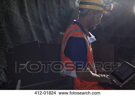 Worker using laptop in tunnel View Large Photo Image Picture - Worker using laptop in tunnel. Fotosearch