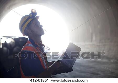 Worker using laptop in tunnel View Large Photo Image Stock Image - Worker using laptop in tunnel. Fotosearch