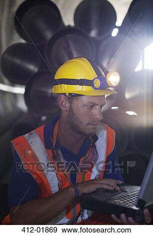 Worker using laptop in tunnel View Large Photo Image Stock Photo - Worker using laptop in tunnel. Fotosearch
