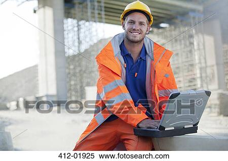 Worker using laptop on site View Large Photo Image Stock Photography - Worker using laptop on site. Fotosearch
