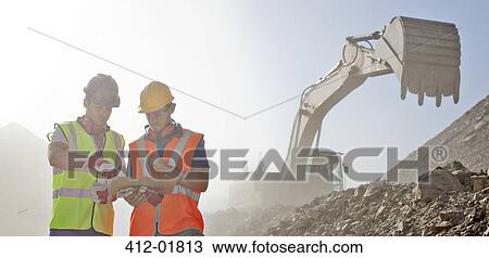 Workers reading blueprints in quarry View Large Photo Image Stock Image - Workers reading blueprints in quarry. Fotosearch