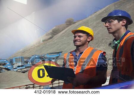 Stock Photo - Workers reflected in window on site. Fotosearch