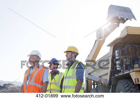 Workers standing on site View Large Photo Image Stock Photo - Workers standing on site. Fotosearch