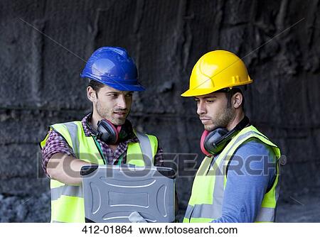 Workers using laptop in tunnel View Large Photo Image Picture - Workers using laptop in tunnel. Fotosearch