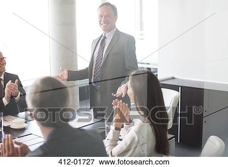 Business people applauding colleague in meeting View Large Photo Image Stock Photo - Business people applauding colleague in meeting. Fotosearch
