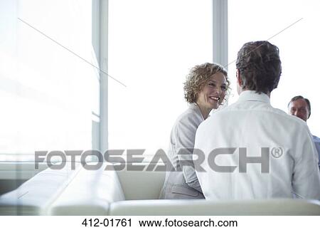 Business people sitting on sofa in office lobby View Large Photo Image Stock Image - Business people sitting on sofa in office lobby. Fotosearch