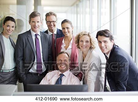 Stock Image - Business people smiling in office. Fotosearch
