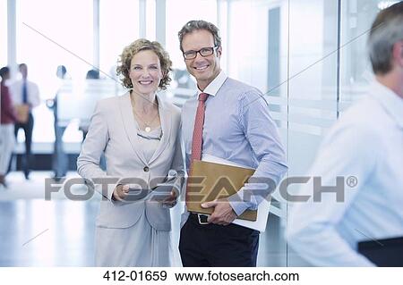 Business people smiling in office hallway View Large Photo Image Stock Photo - Business people smiling in office hallway. Fotosearch