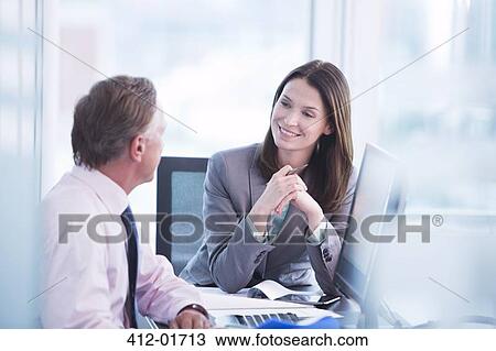 Business people talking at desk View Large Photo Image Stock Image - Business people talking at desk. Fotosearch