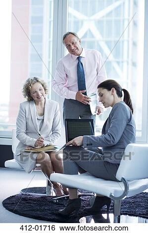 Business people talking in office lobby View Large Photo Image Stock Photograph - Business people talking in office lobby. Fotosearch