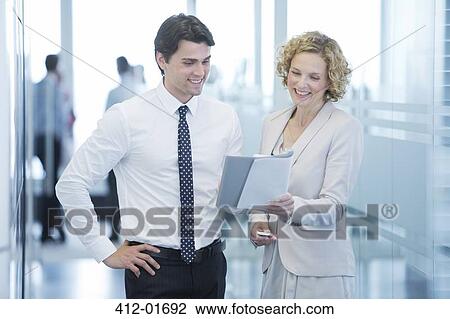 Stock Image - Business people talking in office hallway. Fotosearch