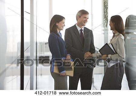 Business people talking in office hallway View Large Photo Image Stock Photo - Business people talking in office hallway. Fotosearch