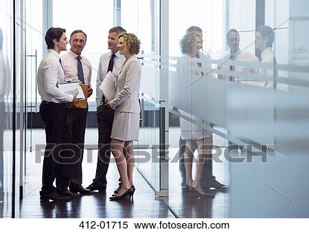 Stock Photography - Business people talking in office hallway. Fotosearch