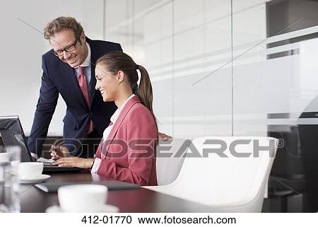 Stock Image - Business people working together in meeting. Fotosearch