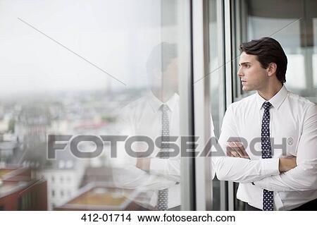 Businessman looking out office window View Large Photo Image Picture - Businessman looking out office window. Fotosearch